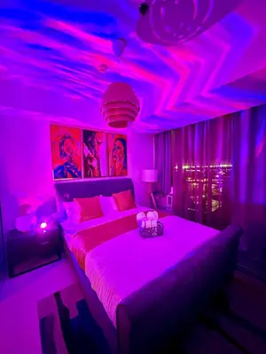 a bedroom with pink lights and a bed in a room at Cityscape Staycation by H&B in Manila