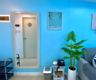 a blue living room with a blue wall and a plant at AZURE MANILA 1721 Bahamas Staycation in Manila