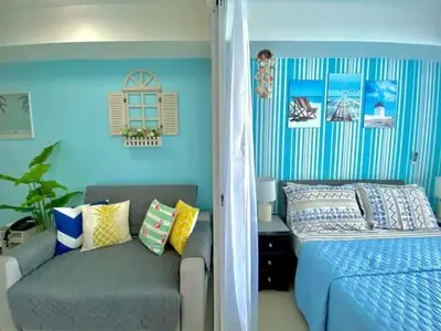 a bedroom with a bed and a couch in it at AZURE MANILA 1721 Bahamas Staycation in Manila