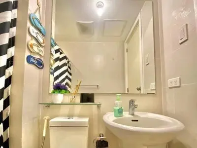 a bathroom with a sink and a mirror and a toilet at AZURE MANILA 1721 Bahamas Staycation in Manila