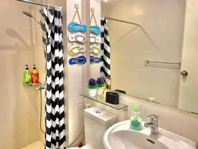 a bathroom with a sink and a toilet and a mirror at AZURE MANILA 1721 Bahamas Staycation in Manila