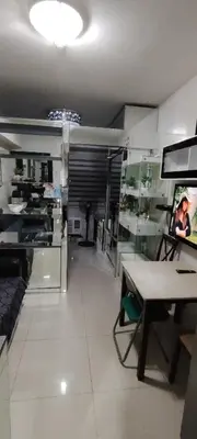 a living room with a table and a room with shelves at Moana's Place Staycation in Manila