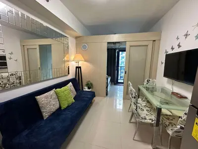 a living room with a blue couch and a table at Moana's Place Staycation in Manila