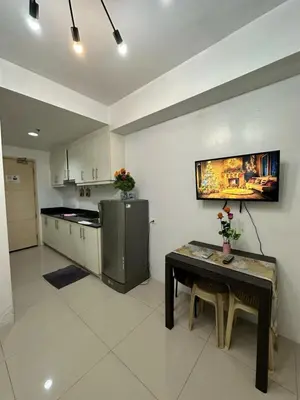 a kitchen with a table and a refrigerator at MOA Complex Staycation in Manila