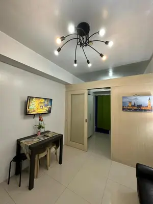 a living room with a table and a chandelier at MOA Complex Staycation in Manila