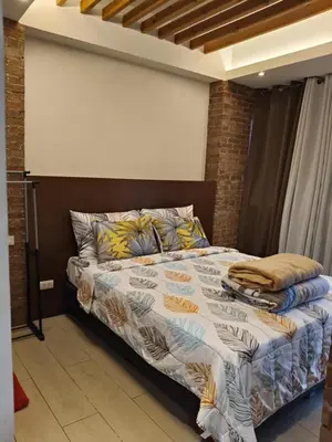 a bedroom with a bed in a room at LDN Two Palm Tree Villas T3 in Manila