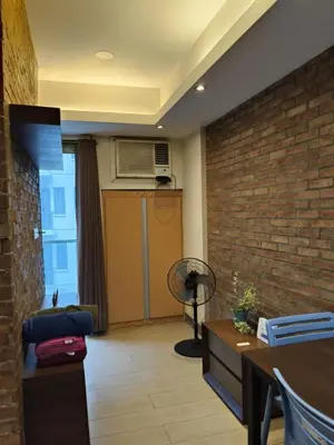 a living room with a brick wall at LDN Two Palm Tree Villas T3 in Manila