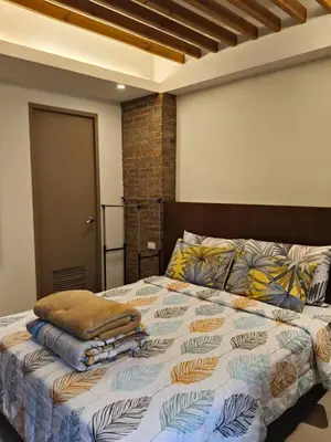 a bedroom with a bed with pillows on it at LDN Two Palm Tree Villas T3 in Manila