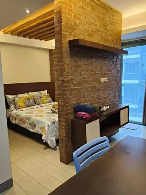 a bedroom with a bed and a brick wall at LDN Two Palm Tree Villas T3 in Manila