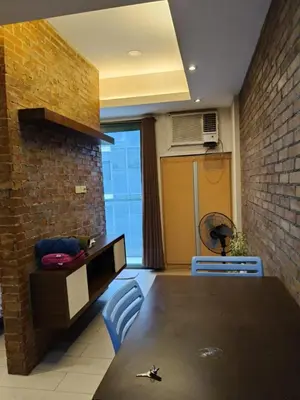 a kitchen with a table and chairs and a brick wall at LDN Two Palm Tree Villas T3 in Manila