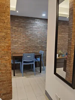 a dining room with a brick wall and a table and chairs at LDN Two Palm Tree Villas T3 in Manila