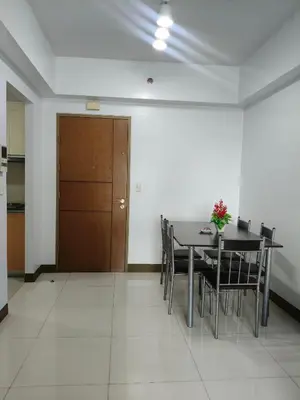 a dining room with a table and chairs and a wooden door at LDN TWO Palm Tree Newport City in Manila
