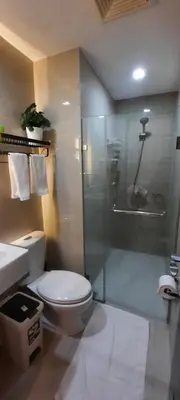 a bathroom with a toilet and a glass shower at D&E suites with balcony in Manila