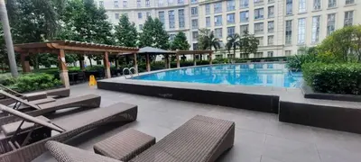a large swimming pool with chairs and a building at D&E suites with balcony in Manila