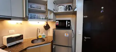 a small kitchen with a refrigerator and a sink at D&E suites with balcony in Manila