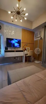 a living room with a large tv on a wall at D&E suites with balcony in Manila