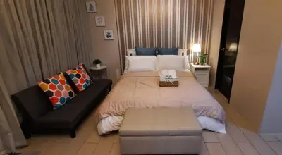 a bedroom with a large bed and a couch at D&E suites with balcony in Manila