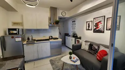 a living room with a couch and a kitchen at Jellybean's Snuggly Cabin in Manila