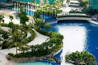 a large pool with palm trees and a bridge at Jellybean's Snuggly Cabin in Manila