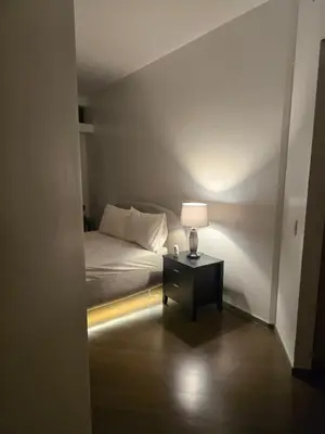 a bedroom with a bed and a table with a lamp at The Imperium Luxury Condominium in Manila