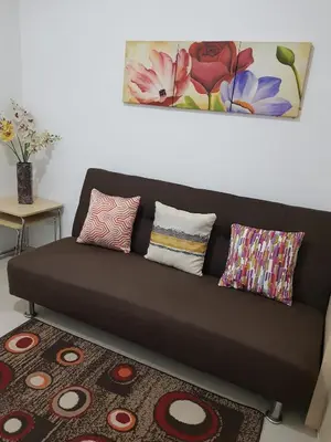 a brown couch in a living room with pillows at 1Br Fully Furnished Condo Unit at Light Residences in Manila