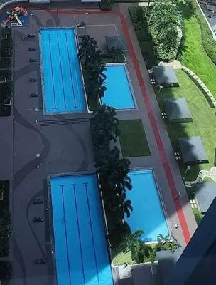 an overhead view of three swimming pools with blue roofs at 1Br Fully Furnished Condo Unit at Light Residences in Manila