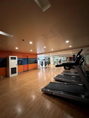 a gym with several treadmills in a room at Mckinley Taguig Staycation in Manila