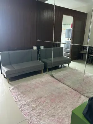 a living room with two blue couches and a mirror at Chay place sea residence in Manila