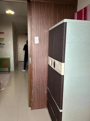 a television in a hallway with a person standing in a room at Chay place sea residence in Manila