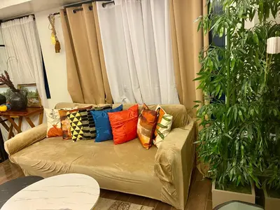 a couch with pillows on it in a living room at Air Residence Luxury condo in Manila