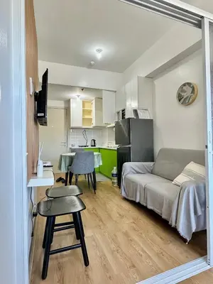 a room with a bed and a table and a kitchen at South Residences Tower in Manila