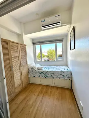 a small room with a bed and a window at South Residences Tower in Manila