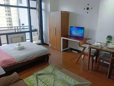 a room with a bed and a desk with a computer at Maleel Rentals in Manila