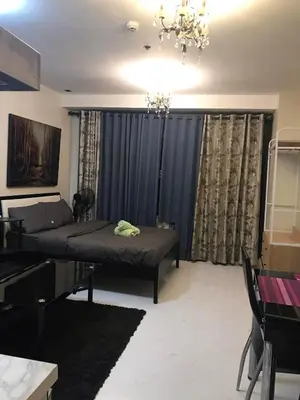 a living room with a bed and a chandelier at Maleel Rentals in Manila