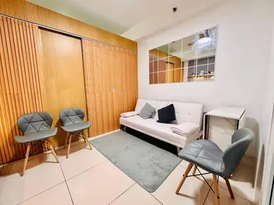 a small room with a couch and two chairs at SMDC Breeze Residences in Manila