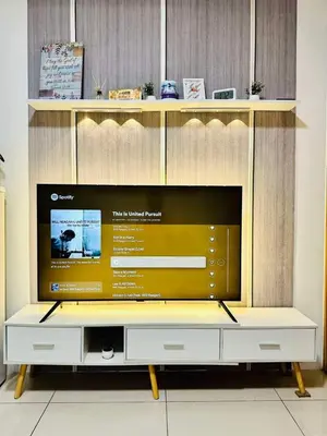 a large entertainment center with a large flat screen tv at SMDC Breeze Residences in Manila