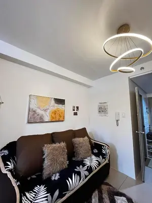 a living room with a couch and a chandelier at Affordable staycation at SHORE RESIDENCES Near MOA and NAIA in Manila