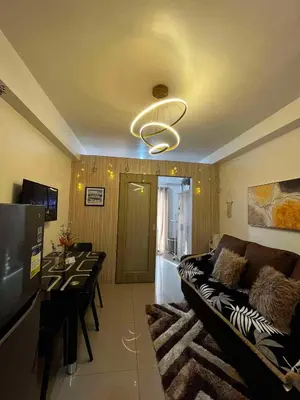 a living room with a couch and a chandelier at Affordable staycation at SHORE RESIDENCES Near MOA and NAIA in Manila