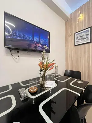 a room with a table with a television on a wall at Affordable staycation at SHORE RESIDENCES Near MOA and NAIA in Manila