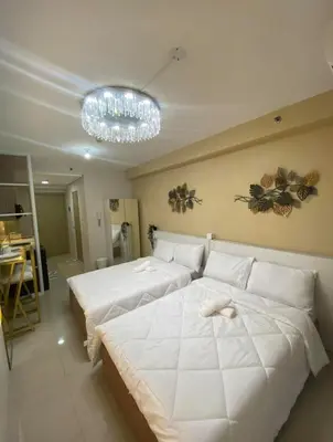 a bedroom with two beds and a chandelier at Stunning Hotel Feels at Shore in Manila