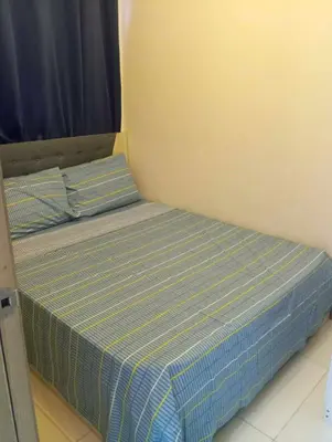 a bed with two pillows on it in a room at Condo next door in Manila
