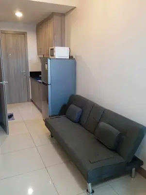 a couch in a living room with a kitchen at Condo next door in Manila
