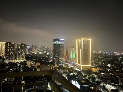 a city skyline at night with tall buildings at Condo next door in Manila