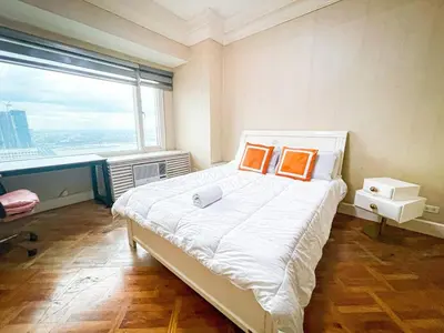 a bedroom with a bed with two orange pillows on it at Stunning & Luxury 4BR in Manila Bay White Beach in Manila