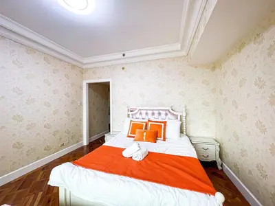 a bedroom with a bed with an orange blanket at Stunning & Luxury 4BR in Manila Bay White Beach in Manila