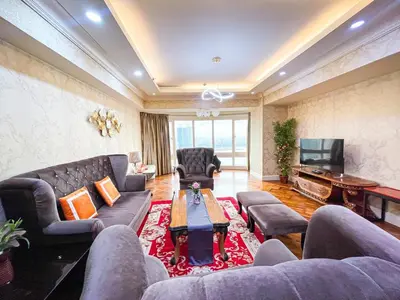 a living room with a couch and a tv at Stunning & Luxury 4BR in Manila Bay White Beach in Manila