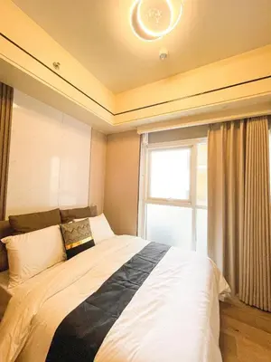 a bedroom with a large bed with a window at Cozy 3BR in Manila Bay near Okada II 12pax in Manila