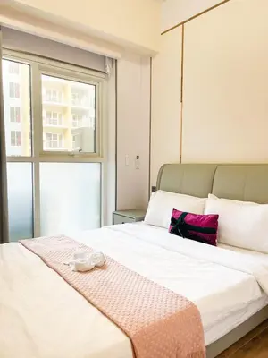 a bedroom with a large white bed with a blanket on it at Cozy 3BR in Manila Bay near Okada II 12pax in Manila