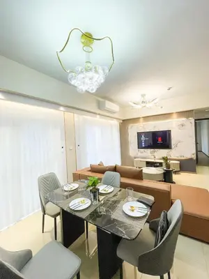 a living room with a table and chairs and a couch at Cozy 3BR in Manila Bay near Okada II 12pax in Manila