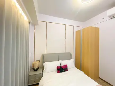 a bedroom with a white bed with two pillows at Cozy 3BR in Manila Bay near Okada II 12pax in Manila